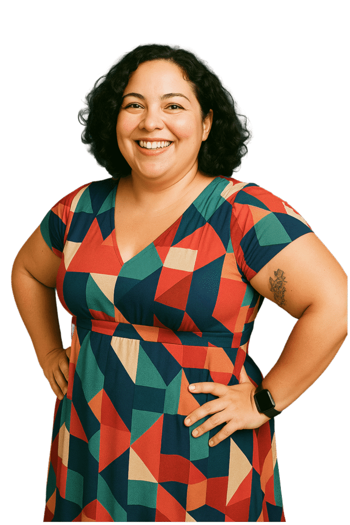 Frau mit dunklem lockigem Haar trägt ein bunt gemustertes Kleid lächelt und legt die Hände in die Hüften