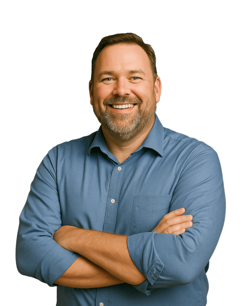 Mann mittleren Alters mit Bart in blauem Hemd verschränkt die Arme und lächelt in die Kamera